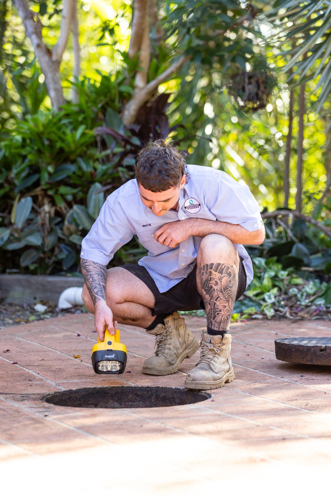 Projection plumber running a CCTV drain camera at an access point